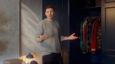 a man standing in front of a closet holding his hands out