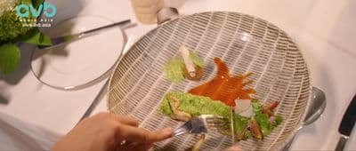 a person holding a fork over a plate with food on it