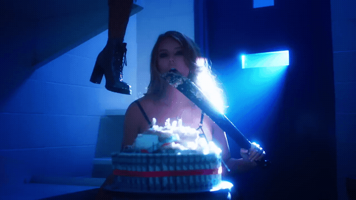 a woman is holding a knife over a birthday cake