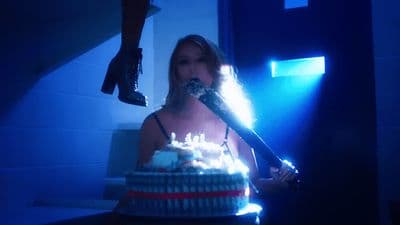 a woman is holding a knife over a birthday cake