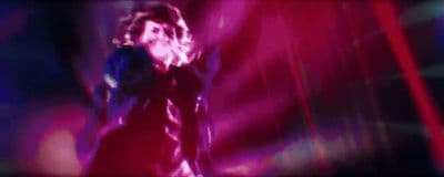 a blurry image of a woman singing into a microphone