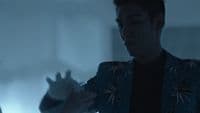 a man holding something in his hand in a dark room