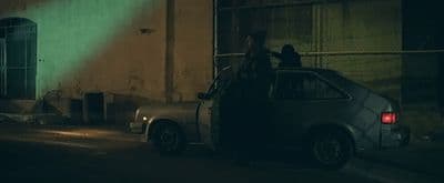 a car parked in front of a building at night