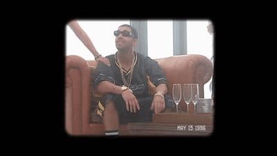 a man sitting on a couch next to wine glasses