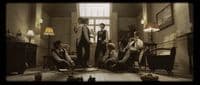 a group of young men standing around a living room