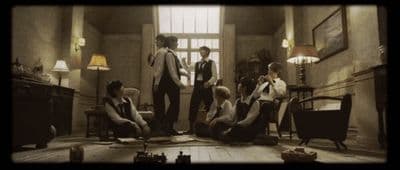 a group of young men standing around a living room
