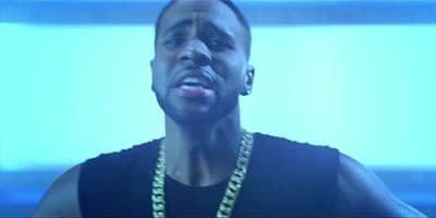 a man in a black shirt wearing a gold chain