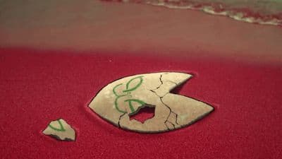 a broken piece of paper sitting on top of a red floor