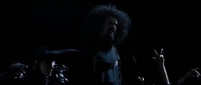 a man with an afro standing in front of a crowd