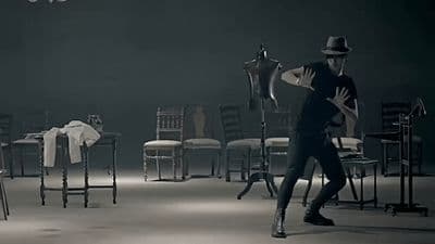 a man standing in a room next to a bunch of chairs