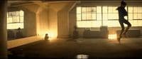 a woman is dancing in a dimly lit room