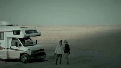 a couple of people standing next to an rv