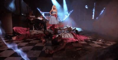 a woman standing on a stage surrounded by people