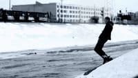 a man riding a snowboard down a snow covered slope