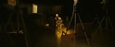 a person sitting in a chair in a dark room