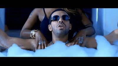 a man laying on top of a foam covered bath tub