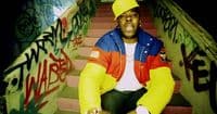 a man sitting on a set of stairs wearing a yellow hat
