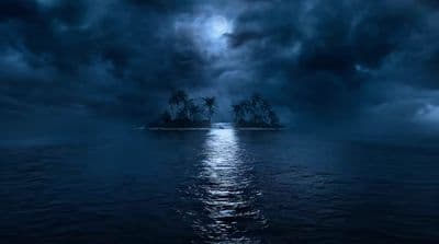 an island in the middle of a body of water under a cloudy sky