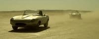 a car driving on a dirt road in the desert