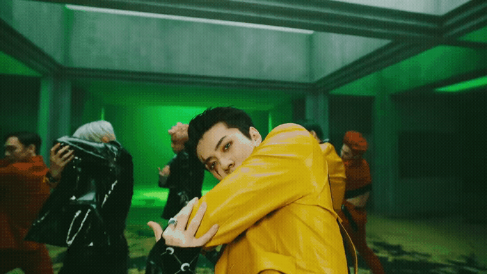 a man in a yellow jacket standing in a room