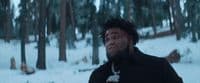 a man with dreadlocks standing in the snow