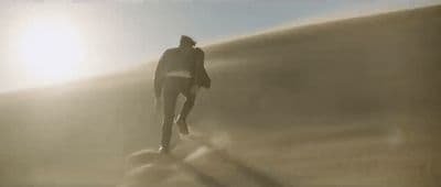a man is walking on a foggy beach