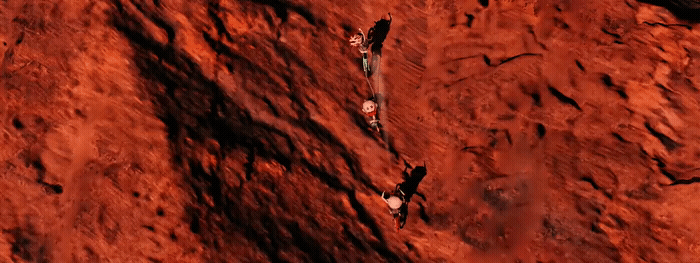 a group of people climbing up a red mountain