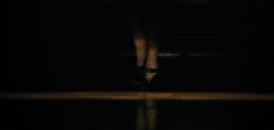 a woman's feet in high heels in the dark
