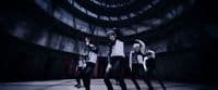 a group of young men dancing in a dark room
