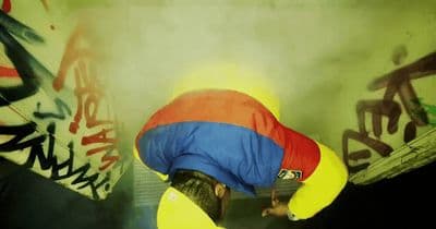 a man in a blue and yellow jacket is bending over