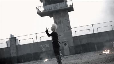 a woman with white hair standing in front of a building