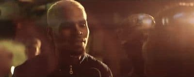 a man with a bald head standing in front of a group of people