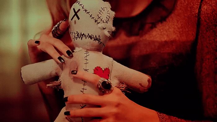 a woman holding a doll with a red heart on it