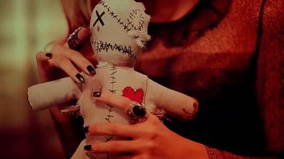 a woman holding a doll with a red heart on it