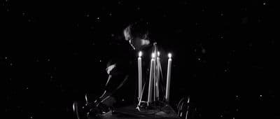 a woman standing in front of a cake with lit candles