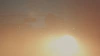 a blurry photo of the sun behind a building