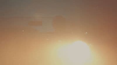 a blurry photo of the sun behind a building