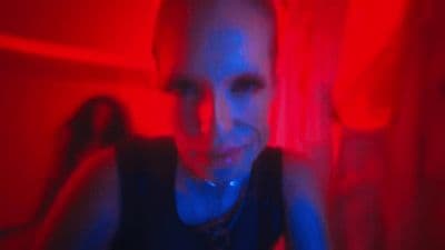 a woman sitting in a room with a red light