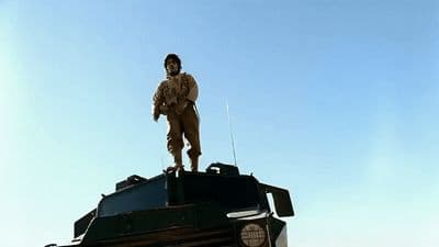 a soldier standing on top of a tank