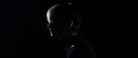 a man in a suit and tie in the dark