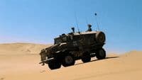 a military vehicle driving through the desert