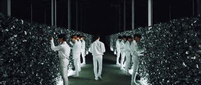 a group of men walking down a tunnel of hedges