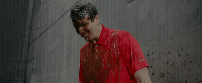a man in a red shirt standing in the rain