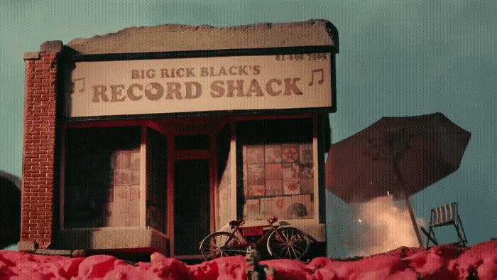 an old record shack with a bicycle parked outside