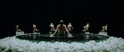 a group of naked women sitting on top of a fountain