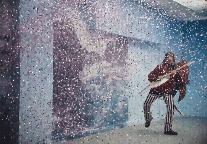 a man with a guitar standing in front of a window