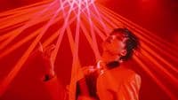 a man standing in front of a red light