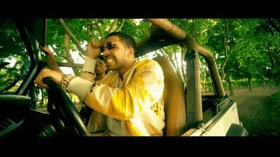 a man driving a car while holding a cell phone to his ear