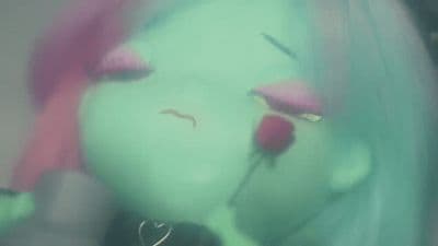 a close up of a doll with pink hair