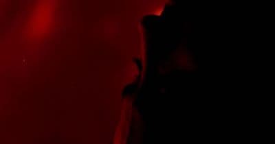 a person standing in front of a red light